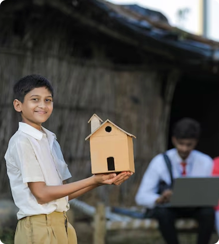 Young school boy holding a model of a house