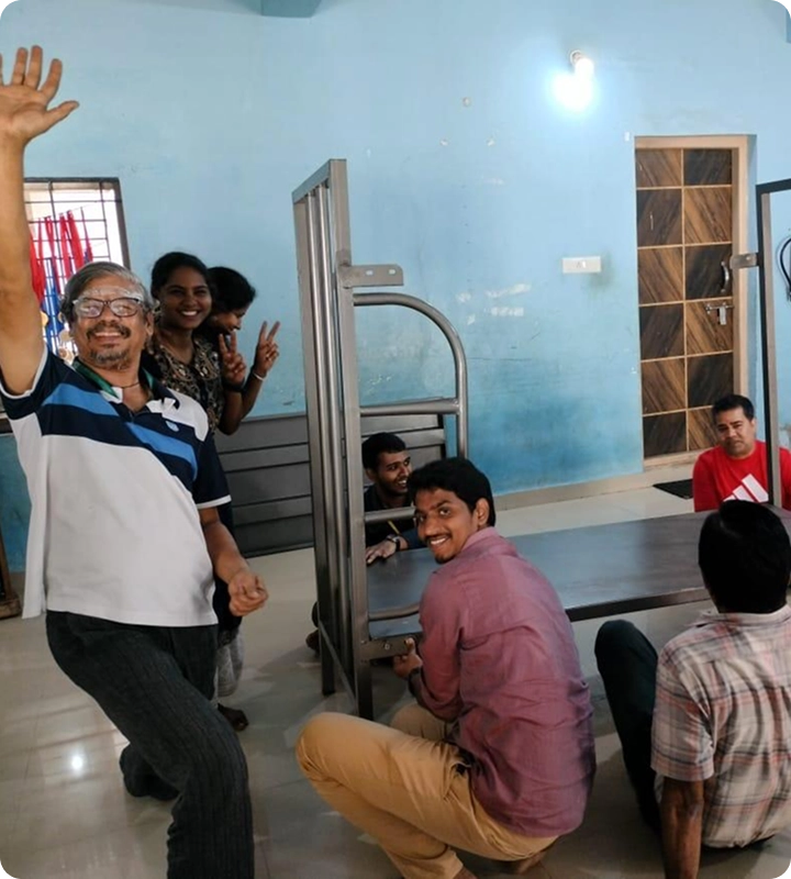 Volunteers smiling for a photo while assembling a bunk bed