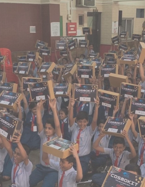 A group of school children holding up cosmo kits